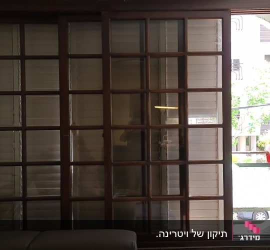 חלון אלומיניום עם תריסים סגורים ומסגרת עץ